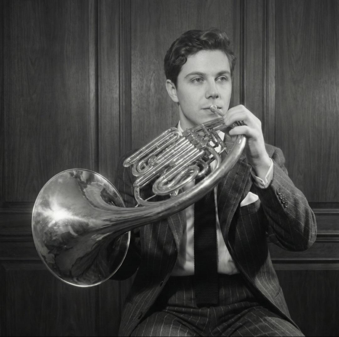 Black and white portrait playing horn in a pinstripe suit