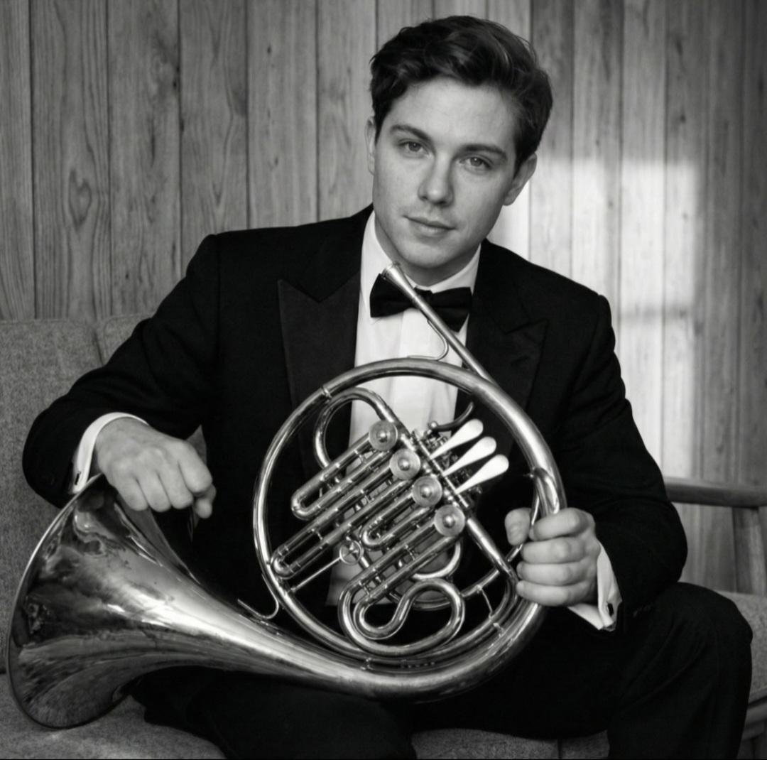 Black and white seated portrait holding French horn